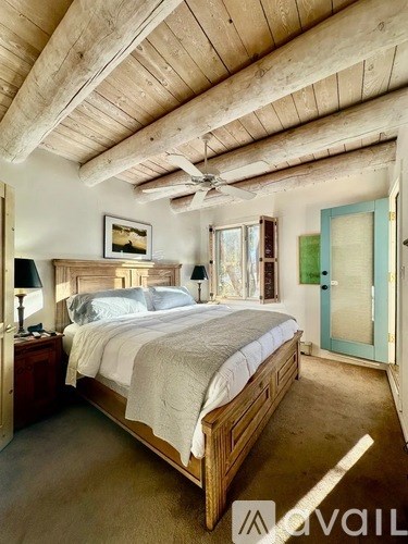 A bedroom with a bed, nightstand, and a ceiling fan.