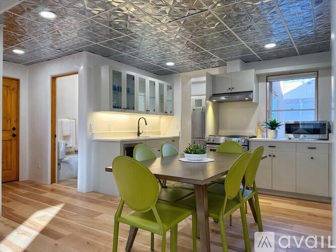 A kitchen with a table and chairs in the foreground.