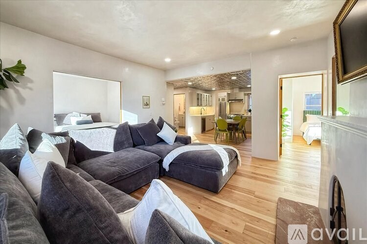 A living room with grey couches and a white wall.