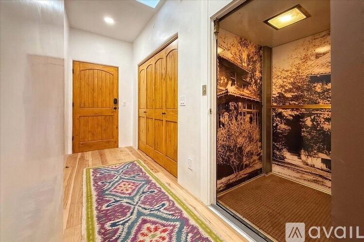 A hallway with wooden doors and a patterned rug.