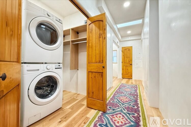 A washer and dryer are sitting on a hardwood floor in a laundry room.