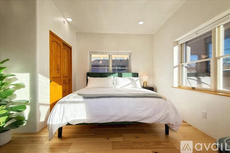 A bedroom with a bed, a window, and a door.