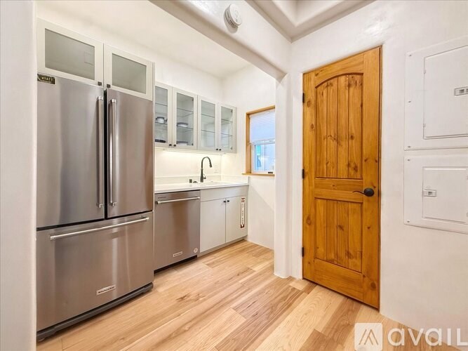 A kitchen with a refrigerator, oven, and sink.