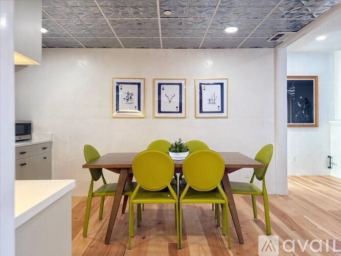 A dining room with a table surrounded by chairs.