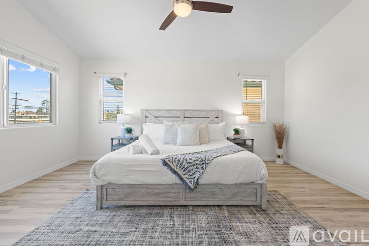A bedroom with a large bed and a ceiling fan.