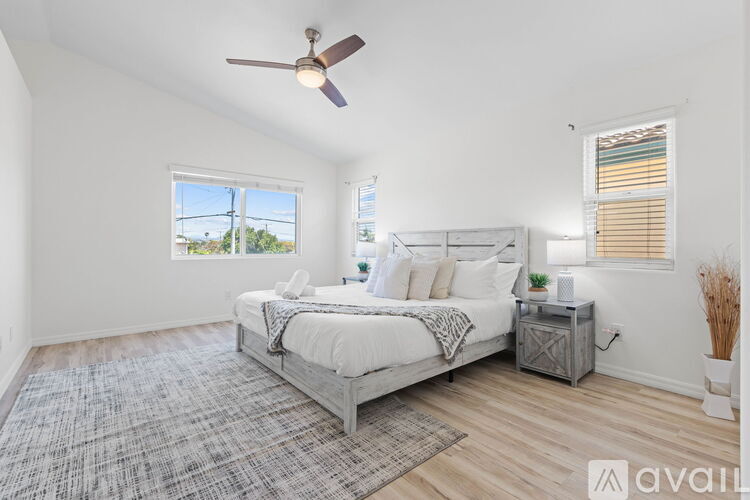 A bedroom with a large bed and a ceiling fan.