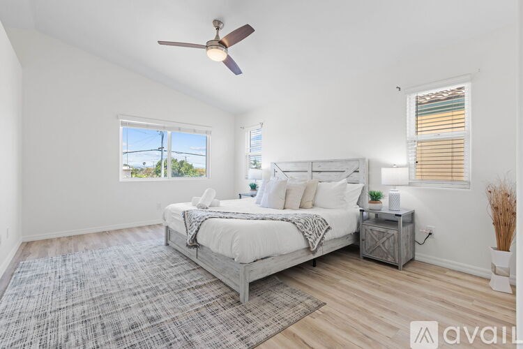 A bedroom with a large bed and a ceiling fan.