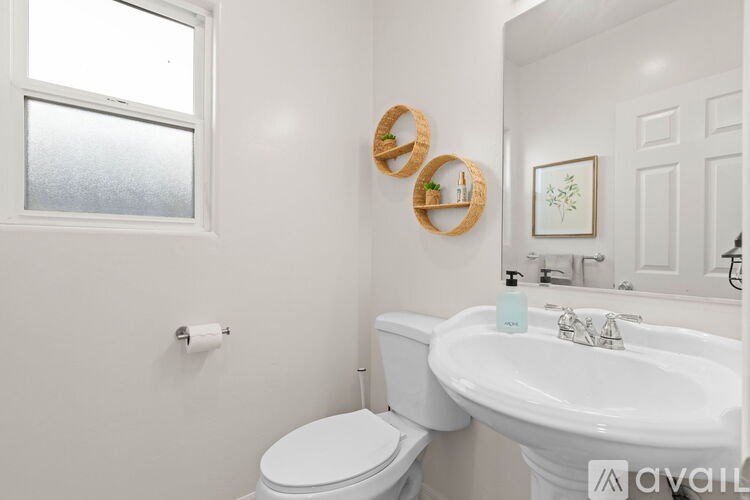 A white toilet sits next to a white sink in a bathroom.