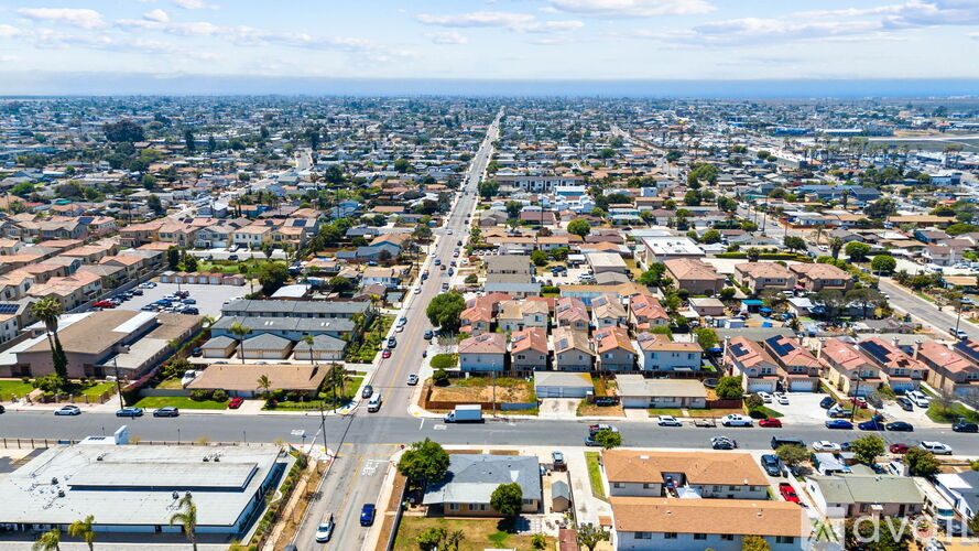 A cityscape with a clear sky and a mix of residential and commercial buildings.