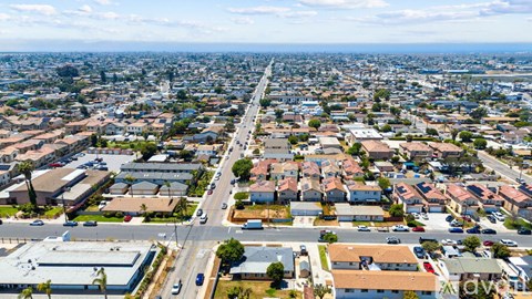 A cityscape with a clear sky and a mix of residential and commercial buildings.