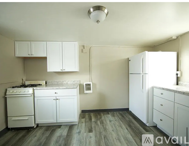 A kitchen with white appliances and cabinets.