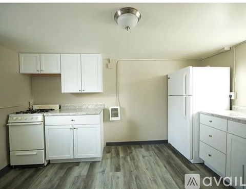 A kitchen with white appliances and cabinets.