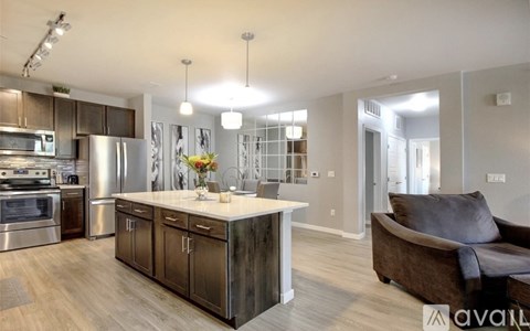 A modern kitchen with a large island and a couch in the living room.