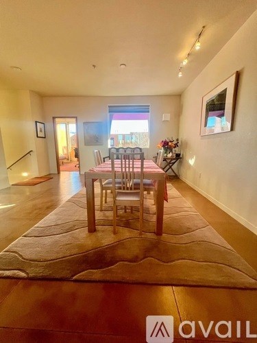 A dining room with a wooden table and chairs.