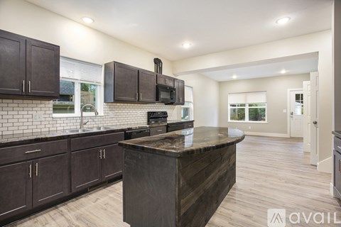 A kitchen with dark wood cabinets and a large island.
