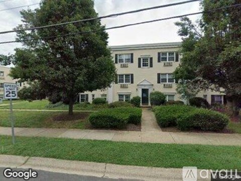 A two-story building with a green lawn in front.