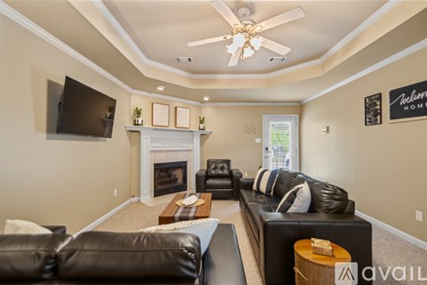 A living room with a fireplace and a flat screen TV mounted on the wall.