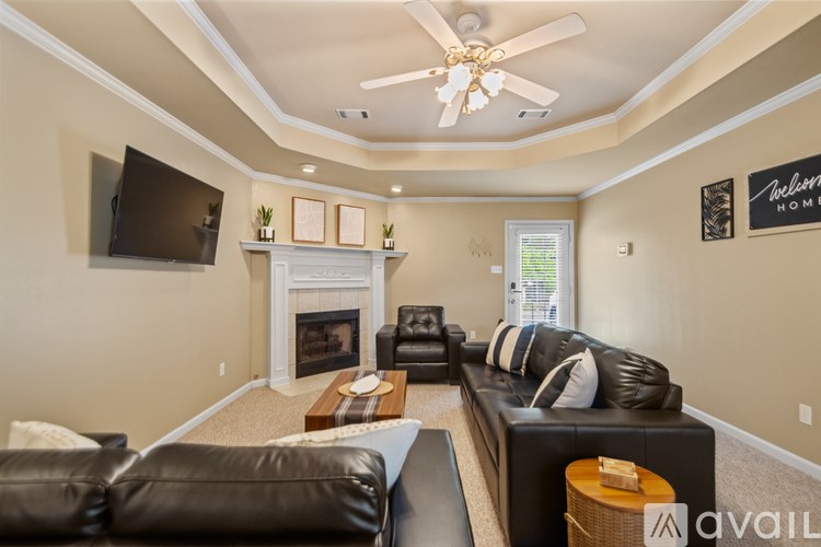 A living room with a fireplace and a flat screen TV mounted on the wall.