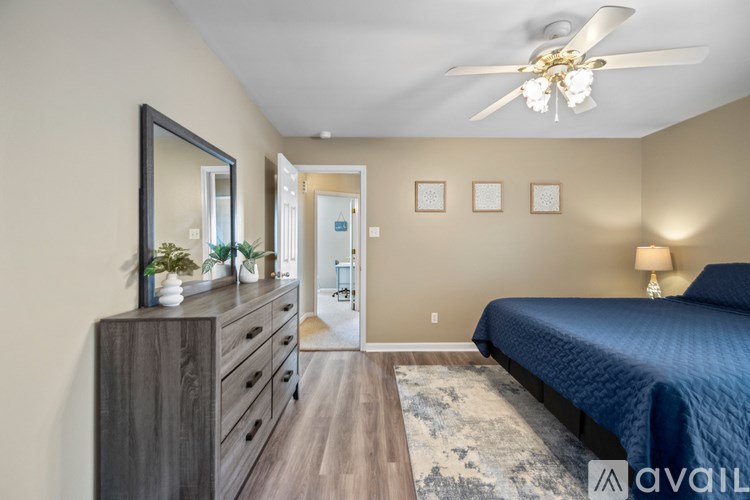 A bedroom with a blue bed and a ceiling fan.