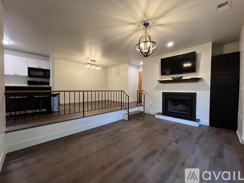 A living room with a fireplace and a television mounted above it.