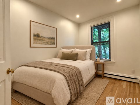 A bedroom with a large bed and a painting on the wall.