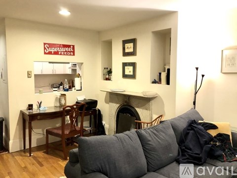 A living room with a grey couch and a fireplace.