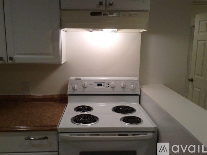A white stove in a kitchen with a brown countertop.