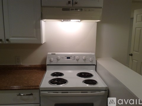 A white stove in a kitchen with a brown countertop.
