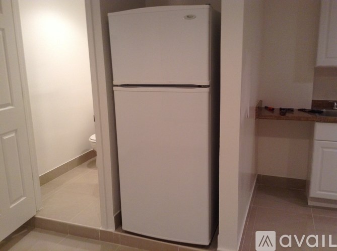 A white refrigerator in a kitchen corner.