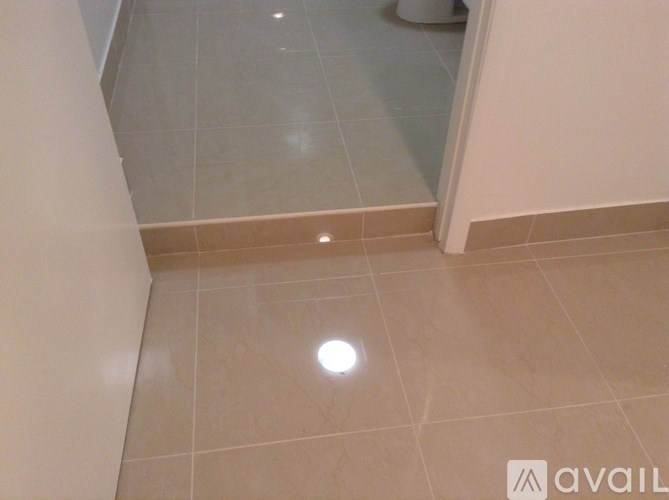 A bathroom with a tiled floor and a toilet in the corner.