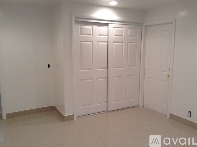 A white bathroom with a toilet, sink, and cabinet.