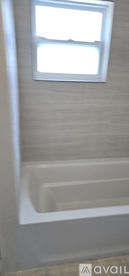 A kitchen with a white door and a white wall.