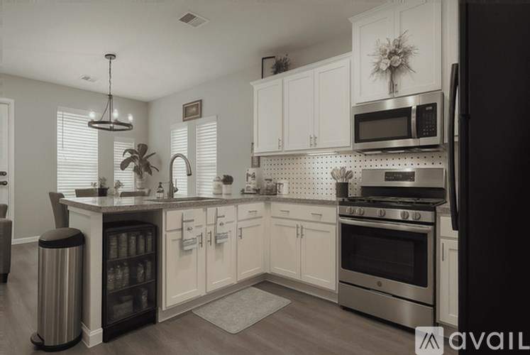 A modern kitchen with white cabinets and stainless steel appliances.