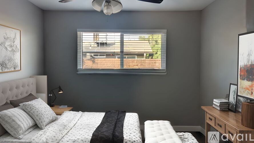 A bedroom with a large bed and a ceiling fan.
