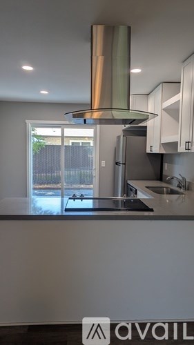 A modern kitchen with a stainless steel refrigerator and a large window.