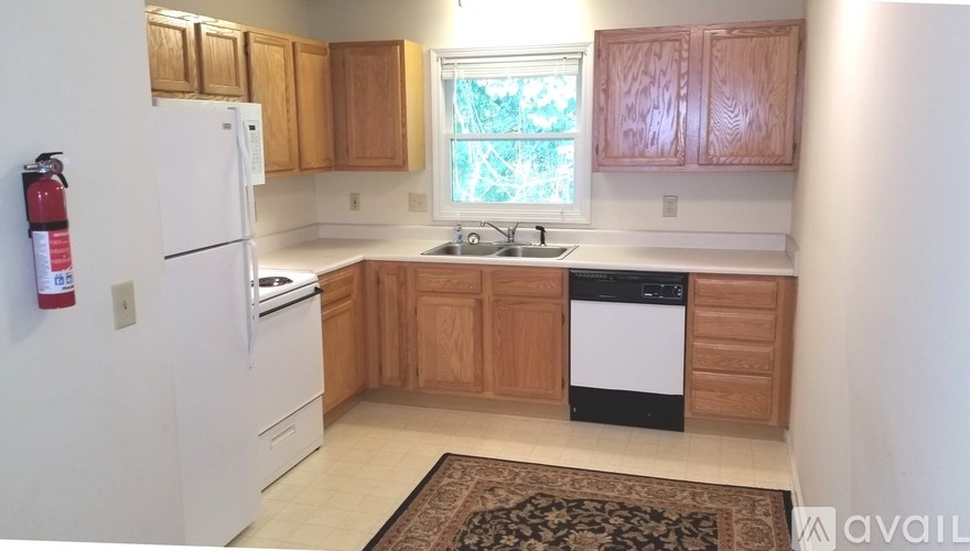 A kitchen with wooden cabinets and a white fridge.