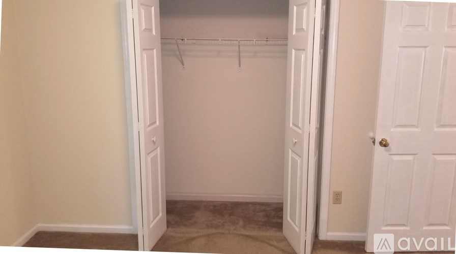 A white closet with a white door and a white wall.