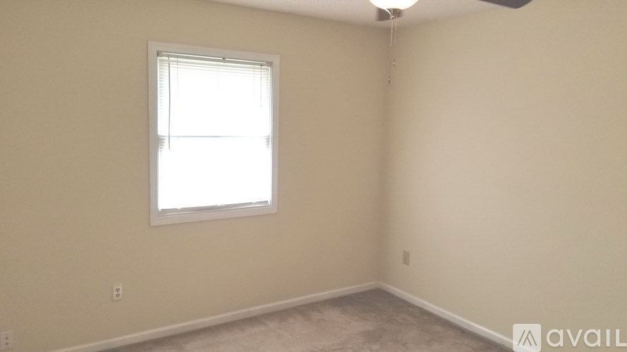 A room with a window and a fan on the ceiling.