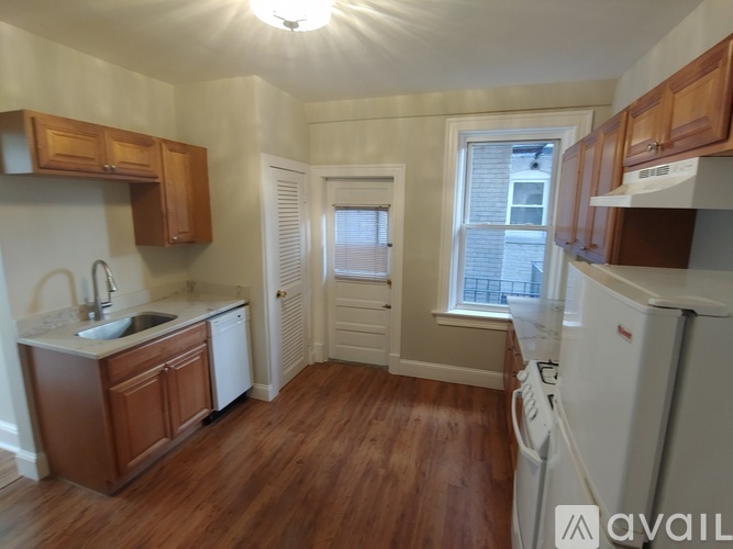 A kitchen with wooden cabinets and a white fridge.