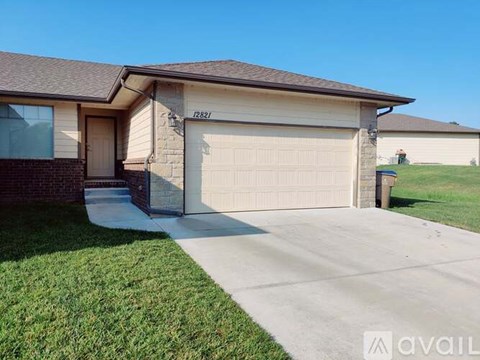 A house with the number 12821 on the front wall and a garage door.