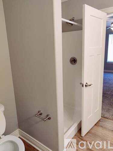 A white door with a silver handle is open.