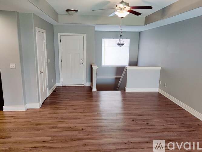 A room with wooden floors and a ceiling fan.