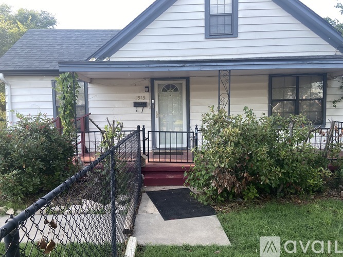 A house with a white front door and a black fence.
