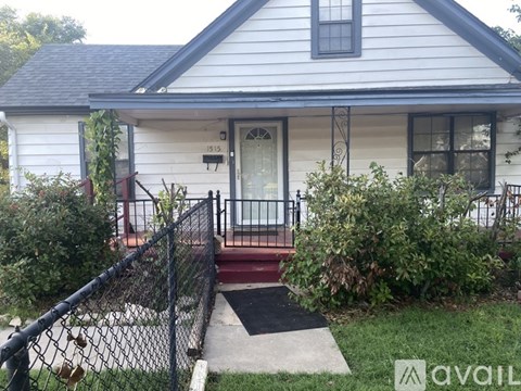 A house with a white front door and a black fence.