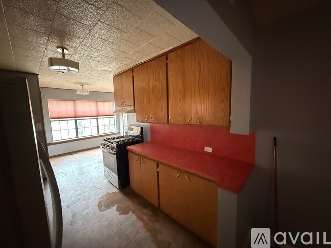 A kitchen with wooden cabinets and a black fridge.