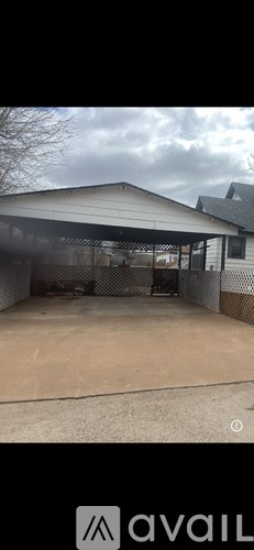A large, open, fenced area with a building in the background.