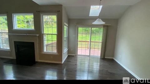 A spacious living room with a fireplace and sliding glass doors leading to a balcony.