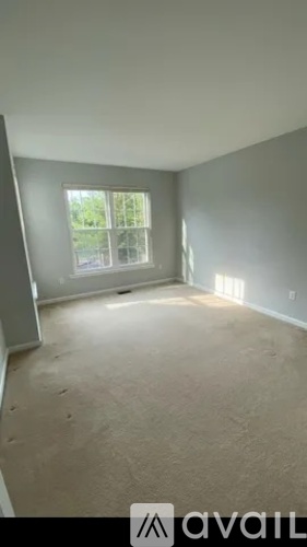 Empty room with a window and a view of trees outside.