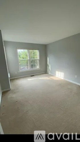Empty room with a window and a view of trees outside.
