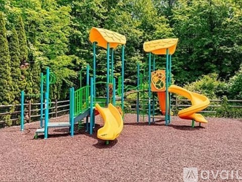 A playground with a yellow slide and green railings.